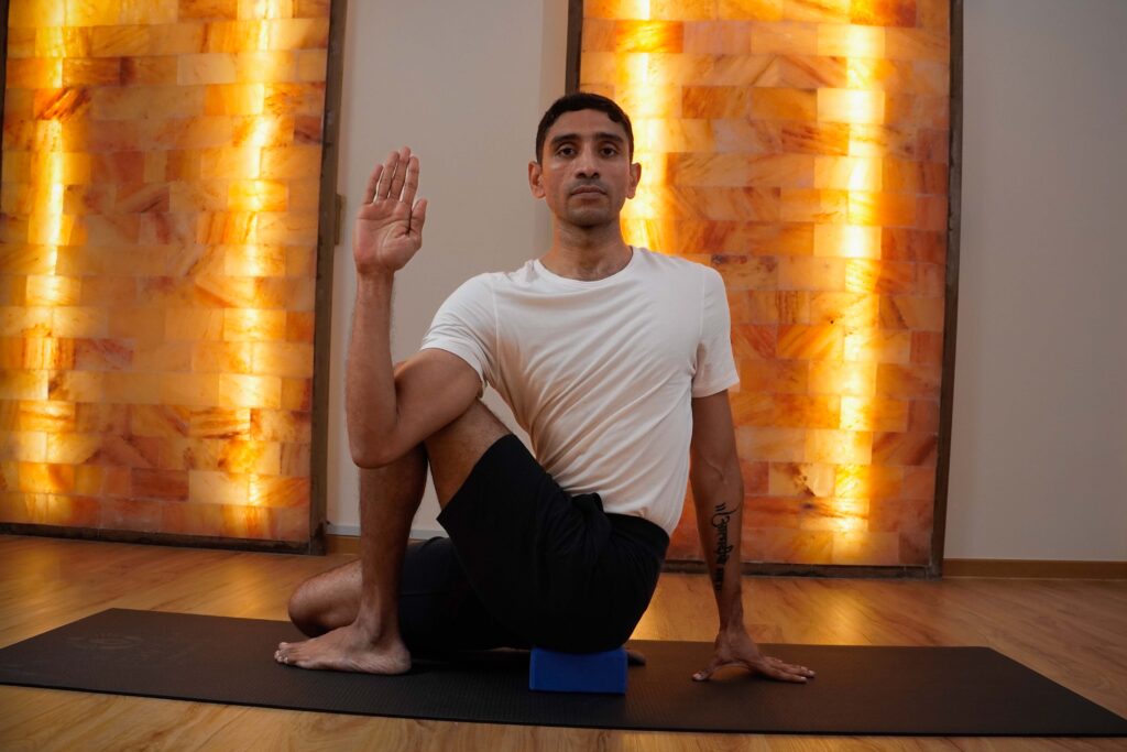 Instructor in a yoga studio practicing shoulder opening pose during class