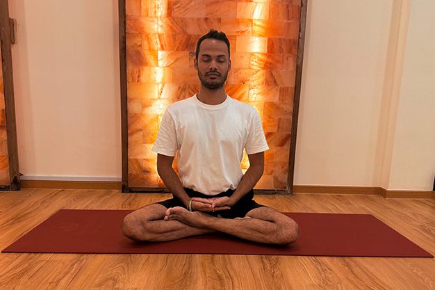 A person in pose during a guided Yoga Nidra session in a serene studio in Singapore.